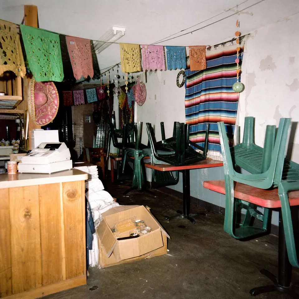 The interior of El Rey, with chairs and colorful textiles on the walls.